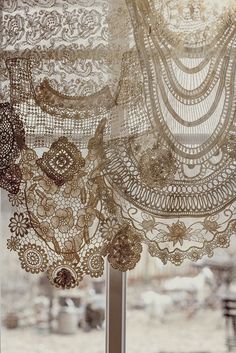 an open window with lace and beads hanging from it