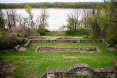 an aerial view of a grassy area next to the water