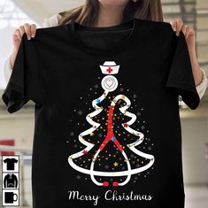 a woman holding up a t - shirt with a christmas tree design on the front