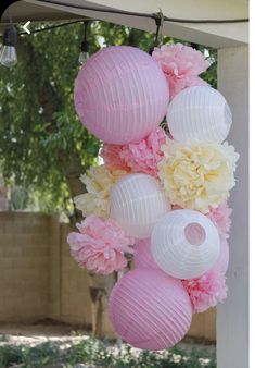 pink and white paper lanterns hanging from the side of a building