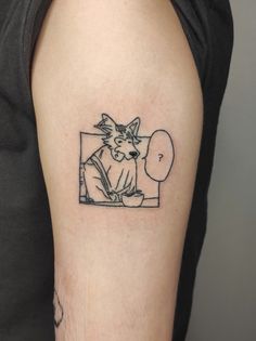 a cat is sitting in front of a mirror tattoo on the left upper half of the arm