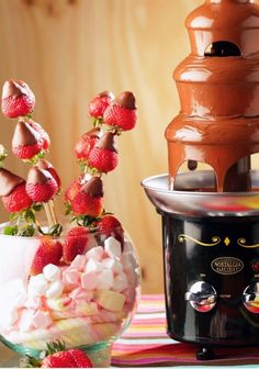 a chocolate fountain with strawberries and marshmallows