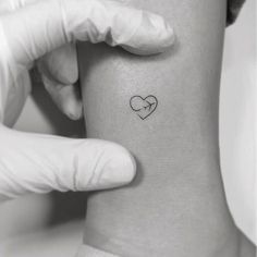 a person with a heart tattoo on their arm