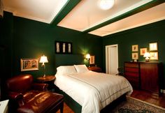 a bedroom with green walls and white bedding