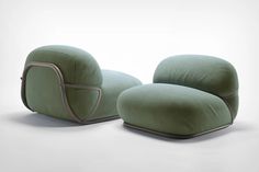 a green chair sitting on top of a white floor next to an ottoman and footstool