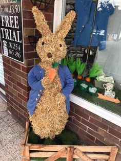 a stuffed rabbit sitting on top of a wooden cart in front of a store window