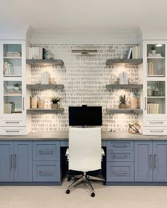 a home office with built - in shelving and desk