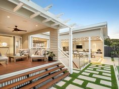 an outdoor living area with wooden steps leading up to the front door and back porch