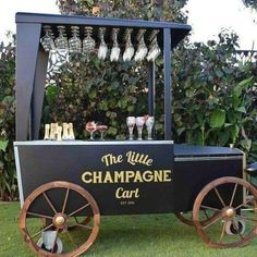 the little champagne cart is decorated with wine glasses and an old fashioned wagon for display