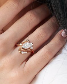 a woman's hand with a gold and white diamond ring on her left hand