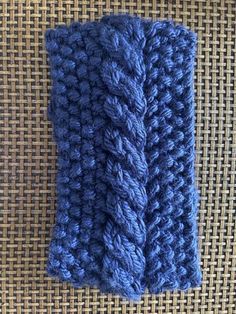 a blue crocheted scarf laying on top of a table