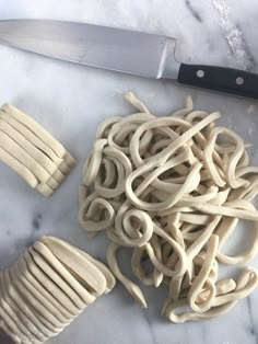 noodles are being prepared on a cutting board