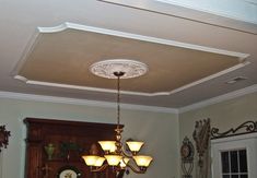 a chandelier hanging from the ceiling in a dining room