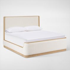 a bed with white sheets and pillows on top of it's headboard is shown