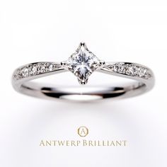 a white gold ring with a princess cut diamond set in the center and side stones