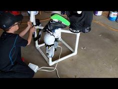 a man working on a motorbike in a room with other items around him