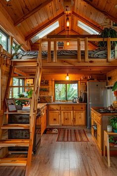 a kitchen with wooden floors and stairs leading up to the loft