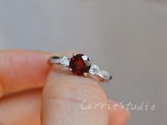 Delicate Garnet ring,  accent with CZ, made with 925 sterling silver, plated with white gold, special birthday or anniversary gift.Main Stone: 6 mm Natural Garnet Accent Stone: CZCS0327Custom Order accepted:Different measurement of stones and ring sizes can be customized.Other natural/lab gemstones can also be customized.Please contact for special request. Garnet Brilliant Cut Ring As Gift, Pear Sapphire Ring, Twisted Band Engagement Ring, Royal Blue Sapphire Ring, Red Gemstone Ring, Twisted Band Ring, Garnet Engagement Ring, Red Garnet Ring, Engagement Rings Twisted