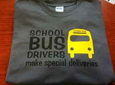 a school bus driver t - shirt sitting on top of a wooden table next to a remote control