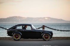 a black car parked next to the ocean