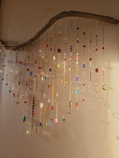 a wind chime hanging from the side of a wall with lots of beads on it