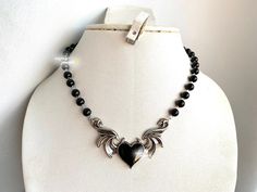 **PLEASE PLACE HOLIDAY ORDERS BEFORE DEC 14 7PM EST!! SHOP BREAK: ORDERS MADE AFTER DEC 15 WILL NOT BE DISPATCHED UNTIL JAN 2 ** THANK YOU ♥ gothic inspired black pearl choker with a winged black heart <3 adjustable chain and can be customized for various lengths.  each size will have a two inch extension to accommodate for different lengths or mismeasurements when measuring neck size the length of the pearls will not exceed 12-13 inches, the rest will be silver chain to accommodate larger sizes Black Grunge Necklace For Gift, Black Alternative Style Choker Necklace, Black Heart-shaped Emo Choker, Black Emo Choker Necklace, Emo Black Choker Necklace, Leather Heart Choker, Grunge Chokers, Green Pearl Earrings, Necklace Grunge