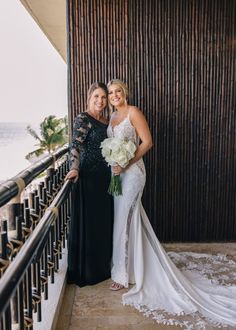 two women standing next to each other on a balcony