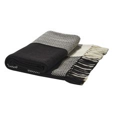 two black and white towels folded on top of each other, one with fringes