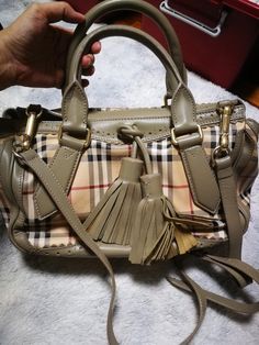 Authentic Burberry handbag Top handle and long strap very good condition  Dustbag included. Measurements Length: 13 inches Height: 7.5 inches Designer Handheld Satchel With Adjustable Strap, Designer Handheld Satchel With Detachable Strap, Designer Satchel With Detachable Handle, Handheld Satchel With Branded Hardware For Shopping, Designer Beige Handheld Satchel, Handheld Satchel For Shopping With Branded Hardware, Chic Shopping Satchel With Double Handle And Branded Hardware, Designer Beige Satchel With Branded Hardware, Top Handle Satchel For Running Errands