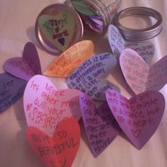 several hearts with writing on them sitting next to two jars