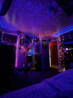 a bedroom decorated in purple and blue lights