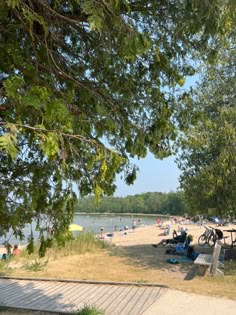 the beach is crowded with people and umbrellas on a sunny day at the water's edge