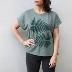 The oversized ferns in our Understory print feel right at home on these new cap sleeve jersey knit tops. They have the casual fit of a boxy top, but the super soft mid-weight fabric gives them a luxurious feel and a feminine drape. Available in sizes S-2XL. FIT & SIZING: - This boxy top is intended to drape loosely - Model shown is 5'8, 36B bust, size 6/8, and she's wearing a medium - Features a ribbed cap sleeve and slight drop shoulder - If you prefer less drape, we strongly recommend sizing d Mom Clothing, Forest Fern, Alpine Forest, Green Jersey, Fern Leaves, Cap Sleeve Tee, Fern Leaf, Boxy Top, Embroidered Clothes