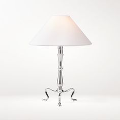 a lamp that is on top of a white surface with a light shade over it