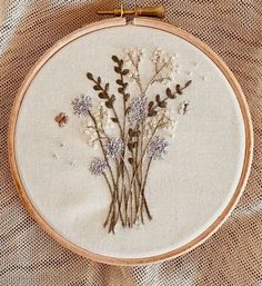 a close up of a embroidery on a piece of cloth with flowers in the middle