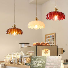 some lights hanging from the ceiling above a counter with food on it and menus