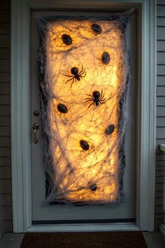 a door decorated with fake spider webs and halloween decorations for the front entrance to a house