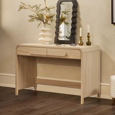 a wooden desk with a mirror and vase on it