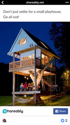 two people standing on the porch of a tree house at night with their lights on