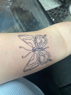 a woman's arm with a tattoo on it that has an image of a butterfly