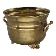 an antique brass pot with handles and feet