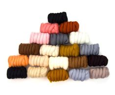 a pile of different colored yarns on a white background