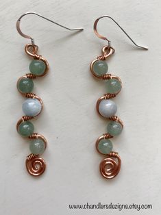 This distinctive pair of earrings is a great statement piece. The frame of each earring is made of copper wire and is evenly curved so beautiful green aventurine stones can sit comfortably in it. Each earring has a lovely aquamarine stone in the center. Each stone is connected to the frame with a thin but durable copper wire.  The wire is attractively hand wrapped around the body of each earring to create a stylish and unique look. These earrings measure two and a quarter (2.25) inches long and Wire Wrapped Jewelry Diy, Wire Jewelry Designs, Wrapped Earrings, Rainbow Jewelry, Diy Wire Jewelry, Wire Work Jewelry, Earrings Inspiration, Handmade Wire Jewelry, Work Jewelry