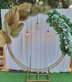 an outdoor ceremony setup with flowers, greenery and hanging lights in front of a white backdrop