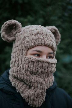 a woman wearing a knitted bear hat and scarf