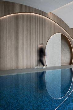 an empty swimming pool next to a wall with circular designs on the walls and floor