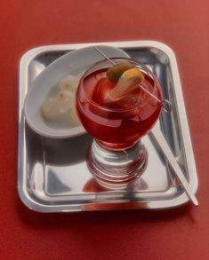 a drink in a glass on a silver tray