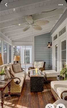 a living room filled with furniture on top of a wooden floor next to a fire place