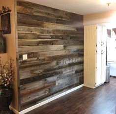 an empty room with wood paneling on the wall and vases next to it