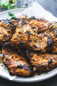 grilled chicken on a white plate with broccoli in the backgroung